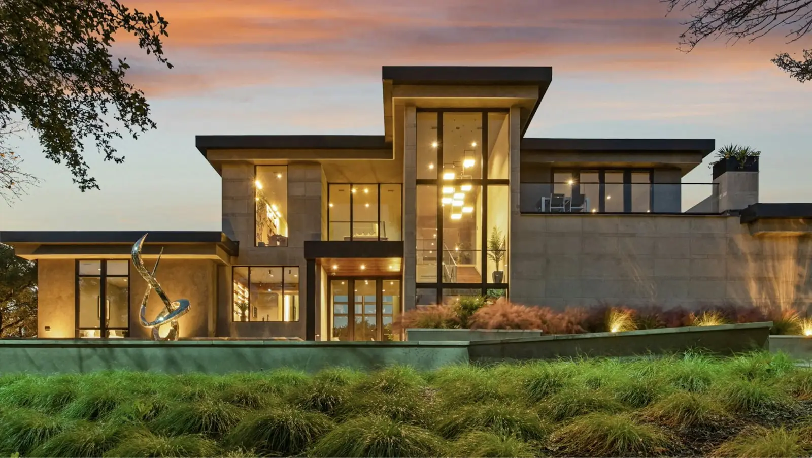 Modern hillside home glowing at dusk